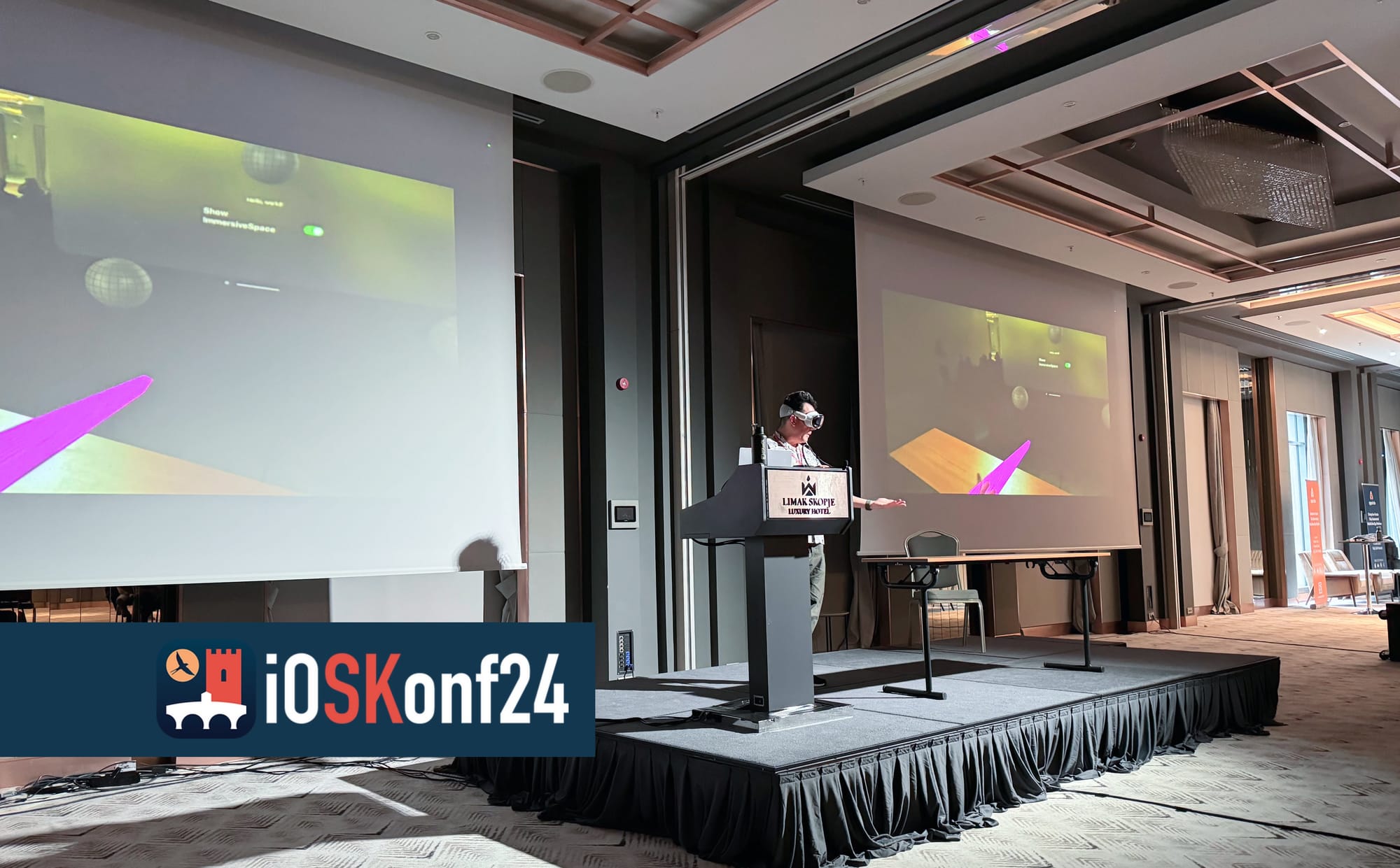 Showing the Vision Pro at a conference podium. Two huge displays behind me display AirPlay live stream